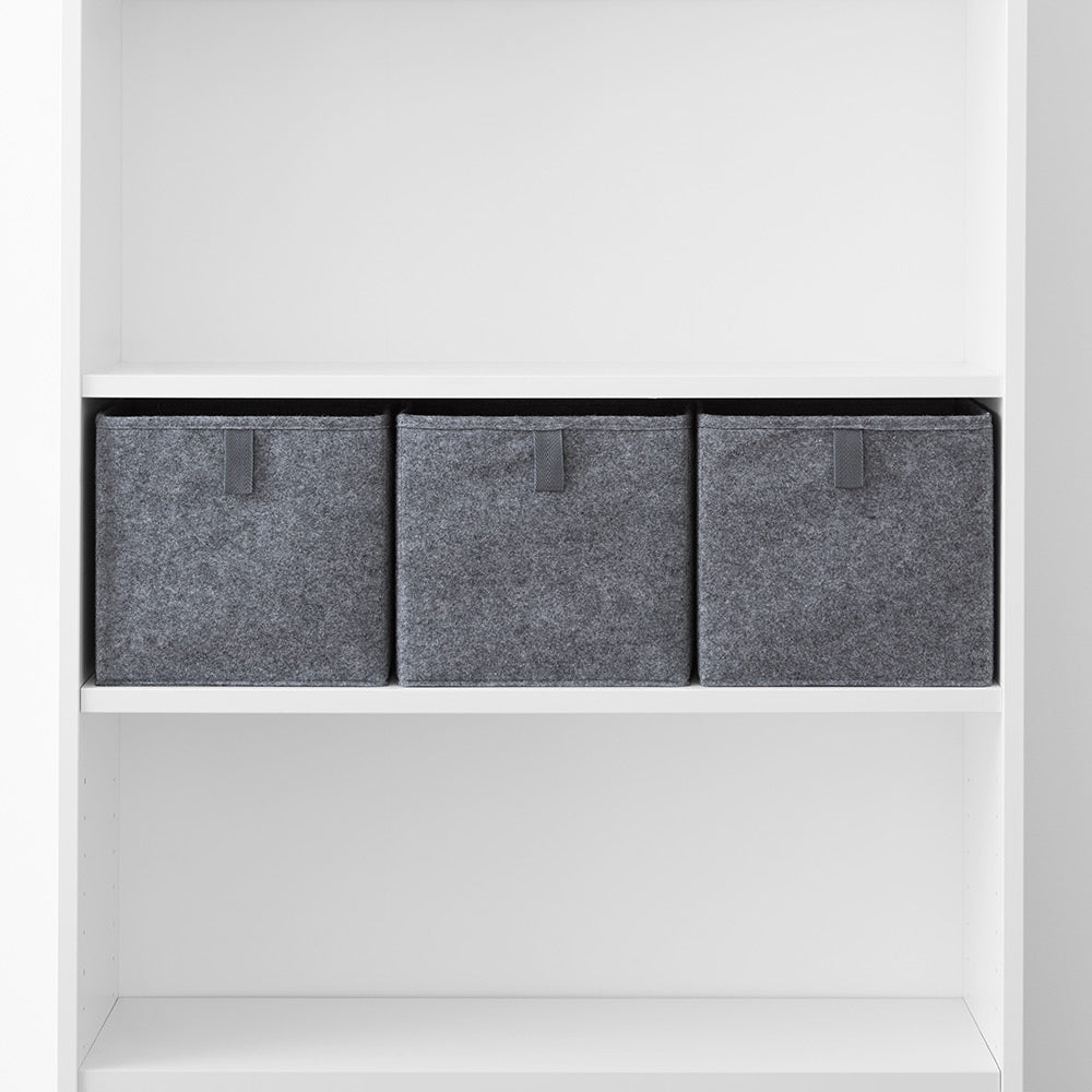 3 graue Aufbewahrungsboxen aus Filz mit Ziehlasche auf einem Regalbrett in einem weißen, 80 cm breiten IKEA Billy Regal.