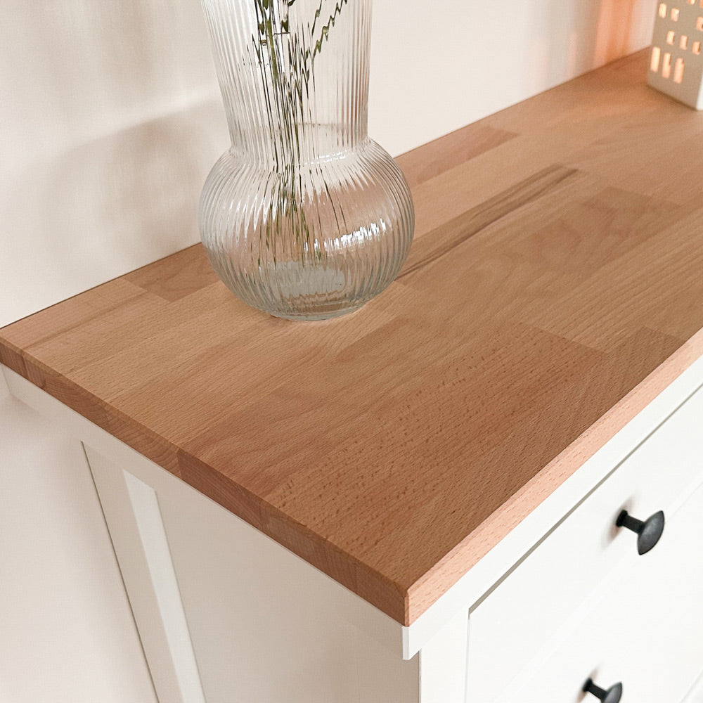 Nahaufnahme von einer Buchenholzplatte, die auf einem weißen IKEA Hemnes Schuhschrank mit 2 Fächern liegt.