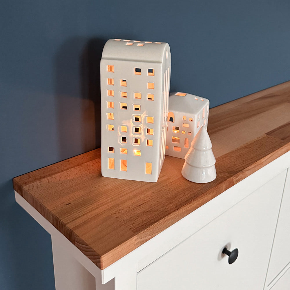 Detailaufnahme von Windlichtern, die auf einer Buchenholzplatte stehen. Diese Platte liegt auf einem weißen IKEA Hemnes Schuhschrank.