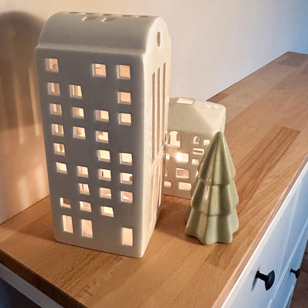 Windlichter mit Kerzen, die auf einer Vollholzplatte aus Buche stehen. Die Holzplatte liegt auf einem weißen Hemnes Schuhschrank von IKEA.
