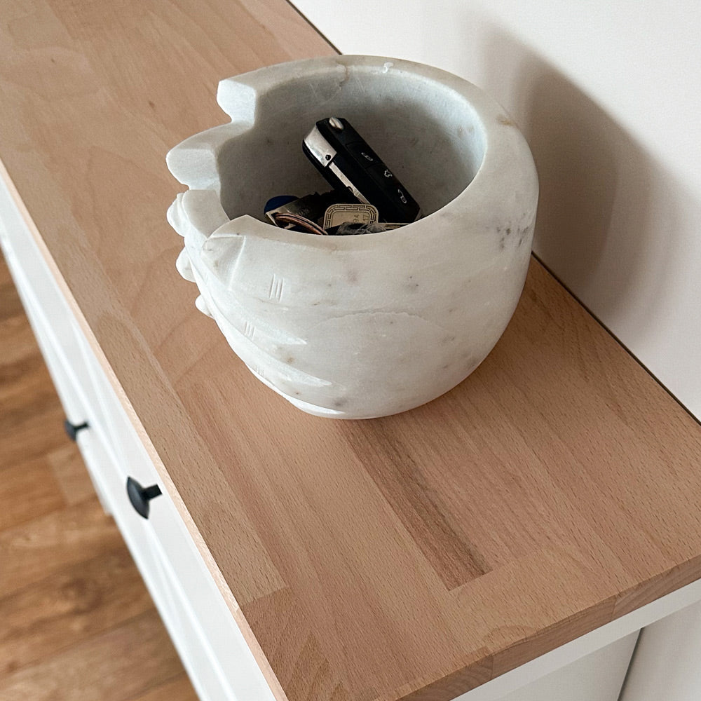 Nahaufnahme von einer ungeölten Buchenholzplatte, die auf einem weißen IKEA Schuhschrank auf der Hemnes Serie liegt. Auf der Holzplatt steht eine Deko-Schale.