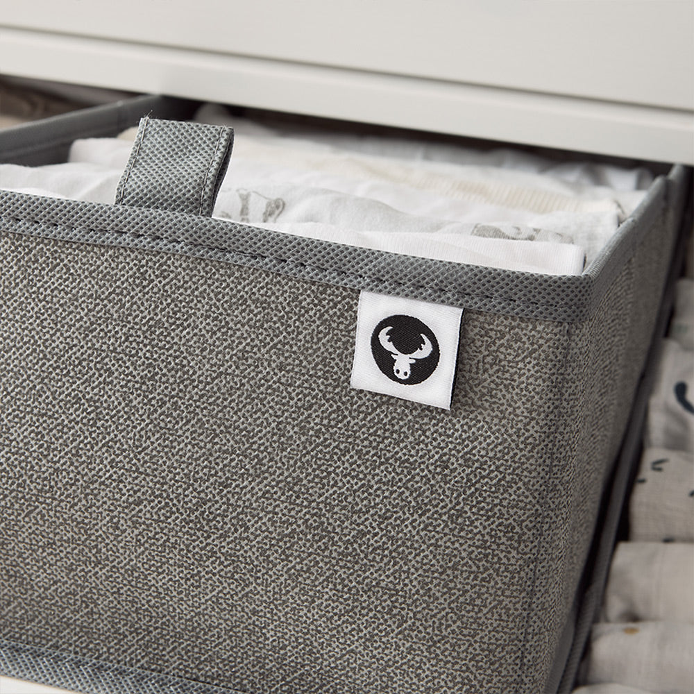 Detailansicht einer grauen Schubladenbox mit Ziehlasche für Kleidung.