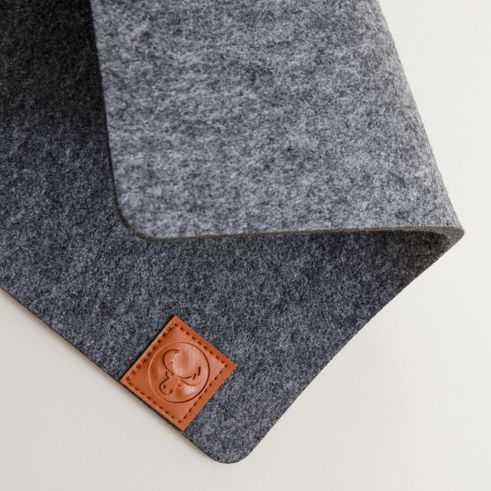 Details einer grau melierten Kallax Bankauflage aus Filz mit New Swedish Design Logo aus braunem Leder.