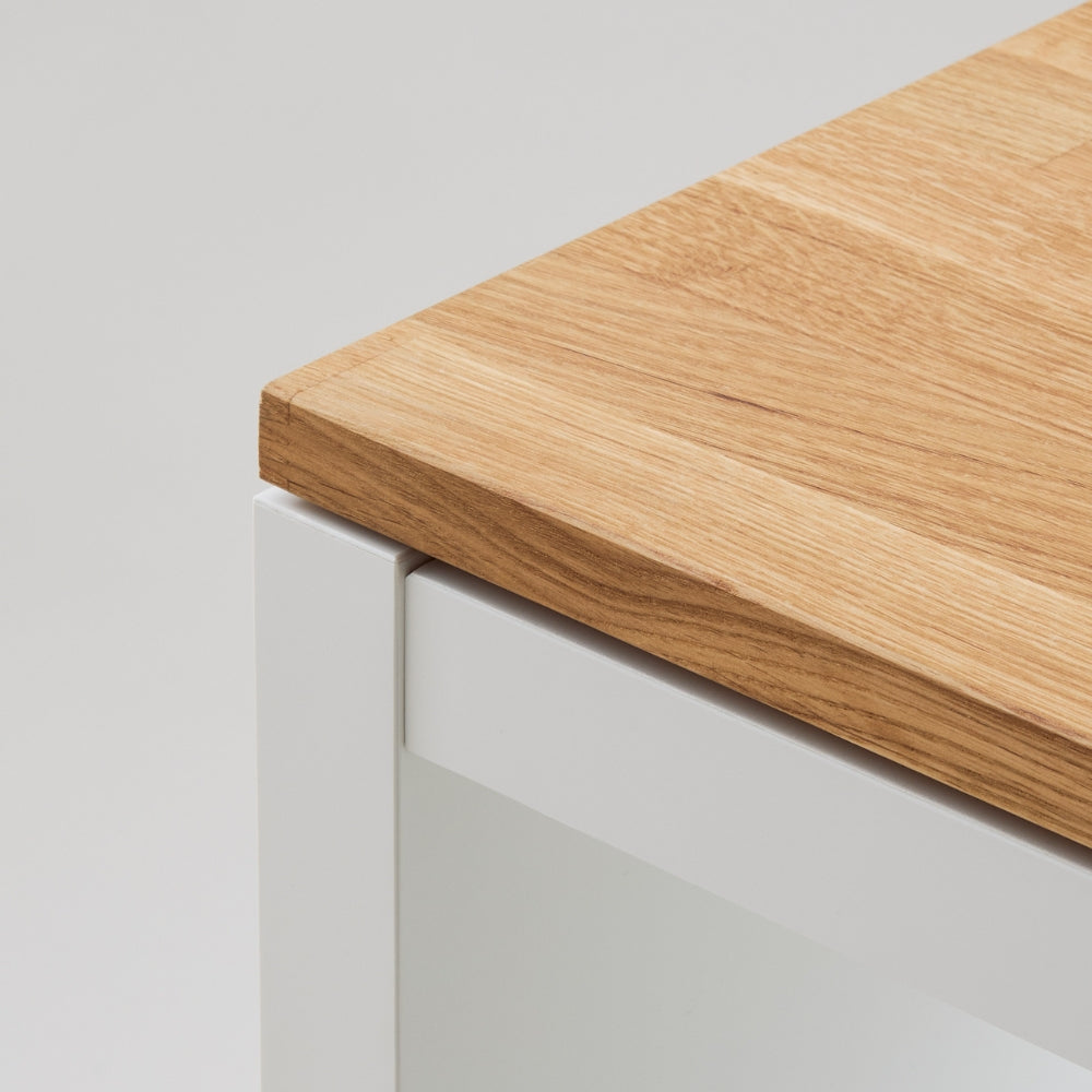 Nahaufnahme einer Kallax Holzplatte aus geöltem Eichenholz, die auf einem IKEA Kallax Regal liegt. Die Ecken sind abgerundet und die Kanten gefast.