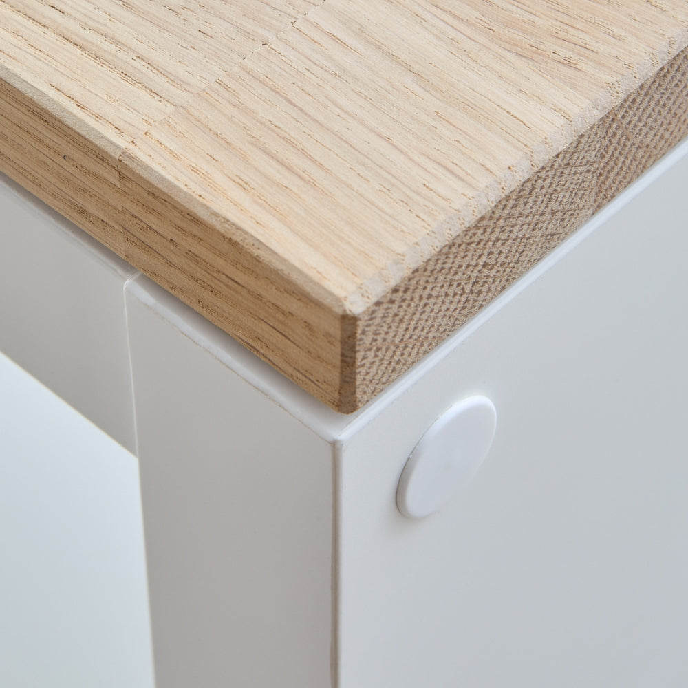 Detailaufnahme von einer Vollholzplatte aus Eichenholz in einer naturbelassenen Ausführung auf einem weißen IKEA Kallax Regal.