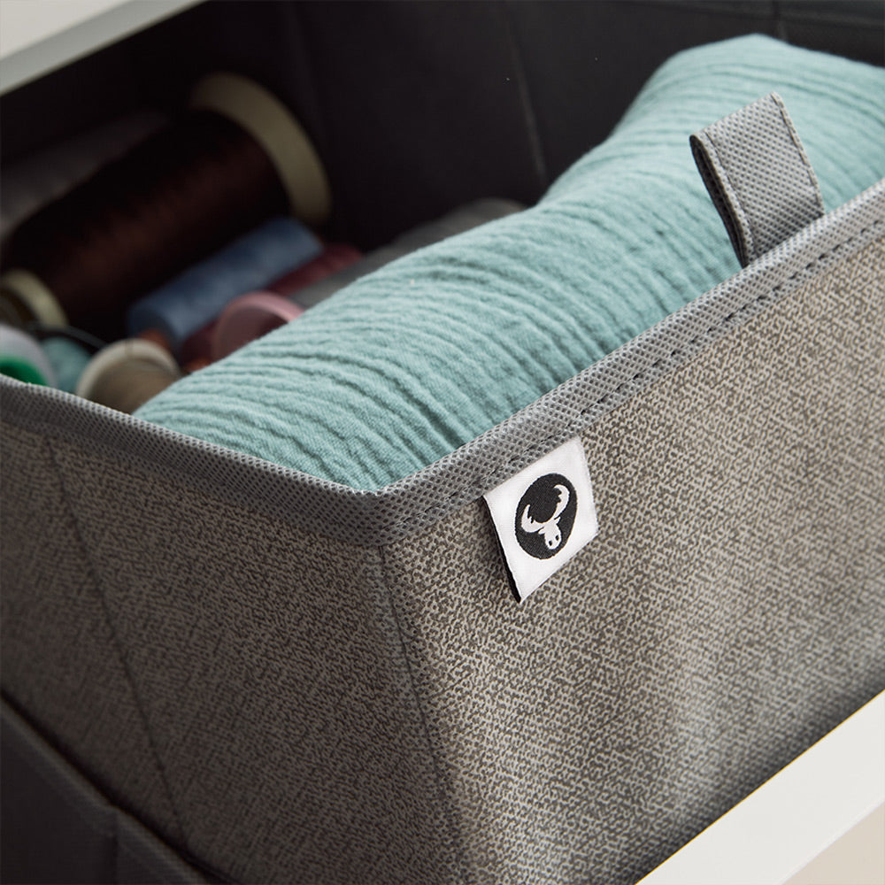 Detailansicht eines gefüllten, grauen Schubladen Organizers mit Ziehlasche