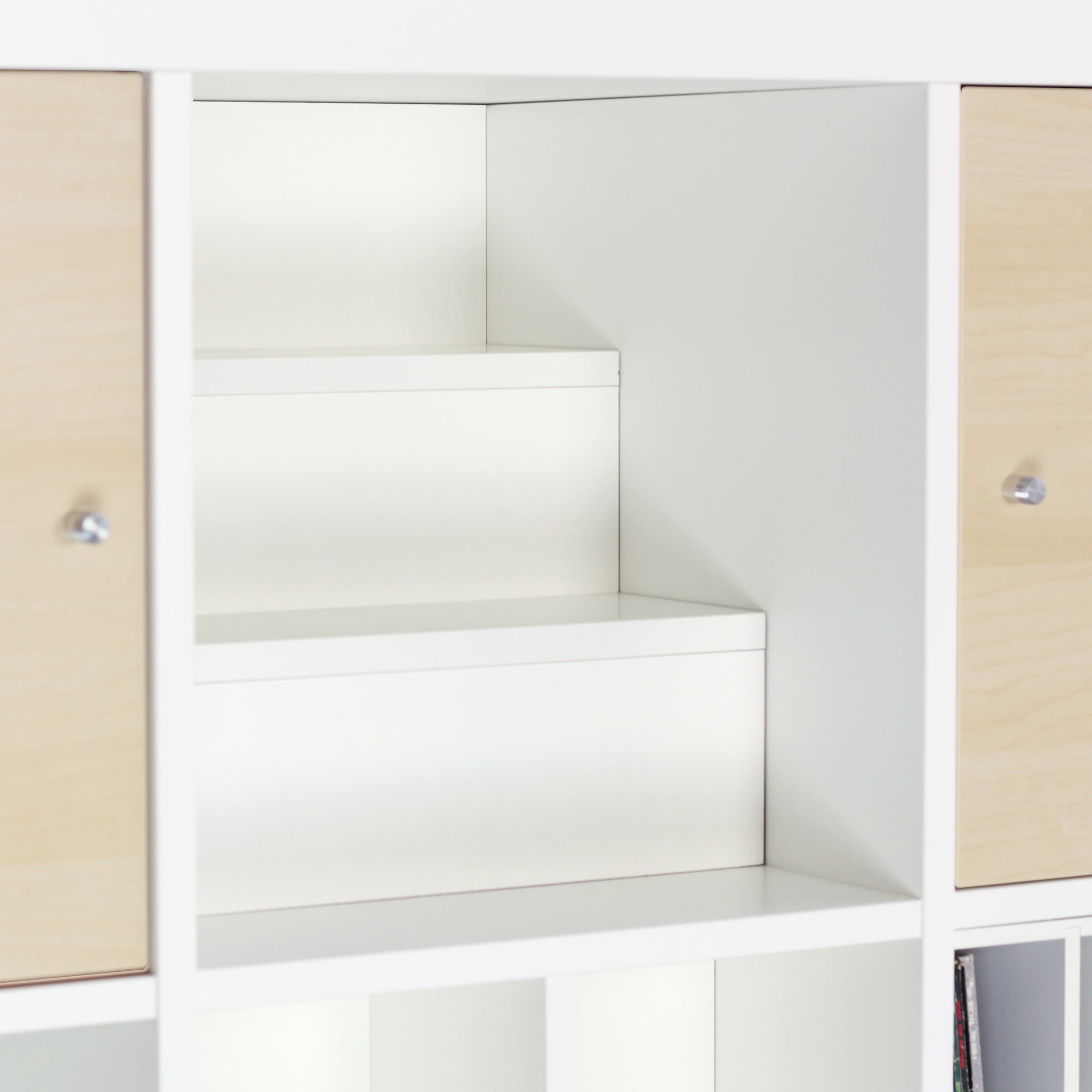 Weißer Kallax Stufeneinsatz im IKEA Kallax Regal.