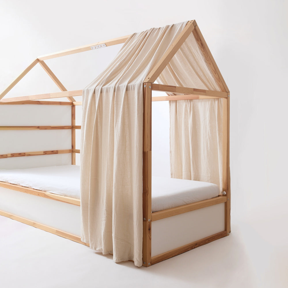 IKEA Kura Kinderbett mit Dach und einem Betthimmel aus Musselin in Beige.
