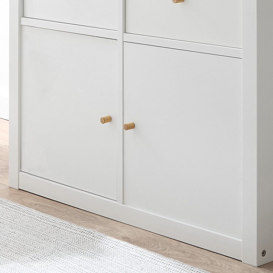 Weißes Kallax Regal mit Türen, an denen Möbelknöpfe aus Eichenholz montiert wurden.