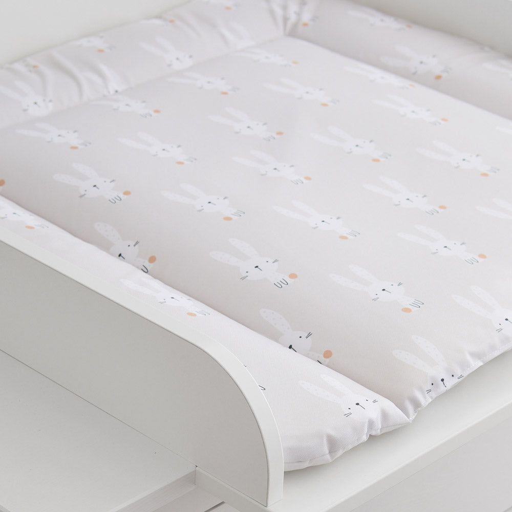 Beige Wickelauflage mit Hasen in einem Wickelaufsatz.