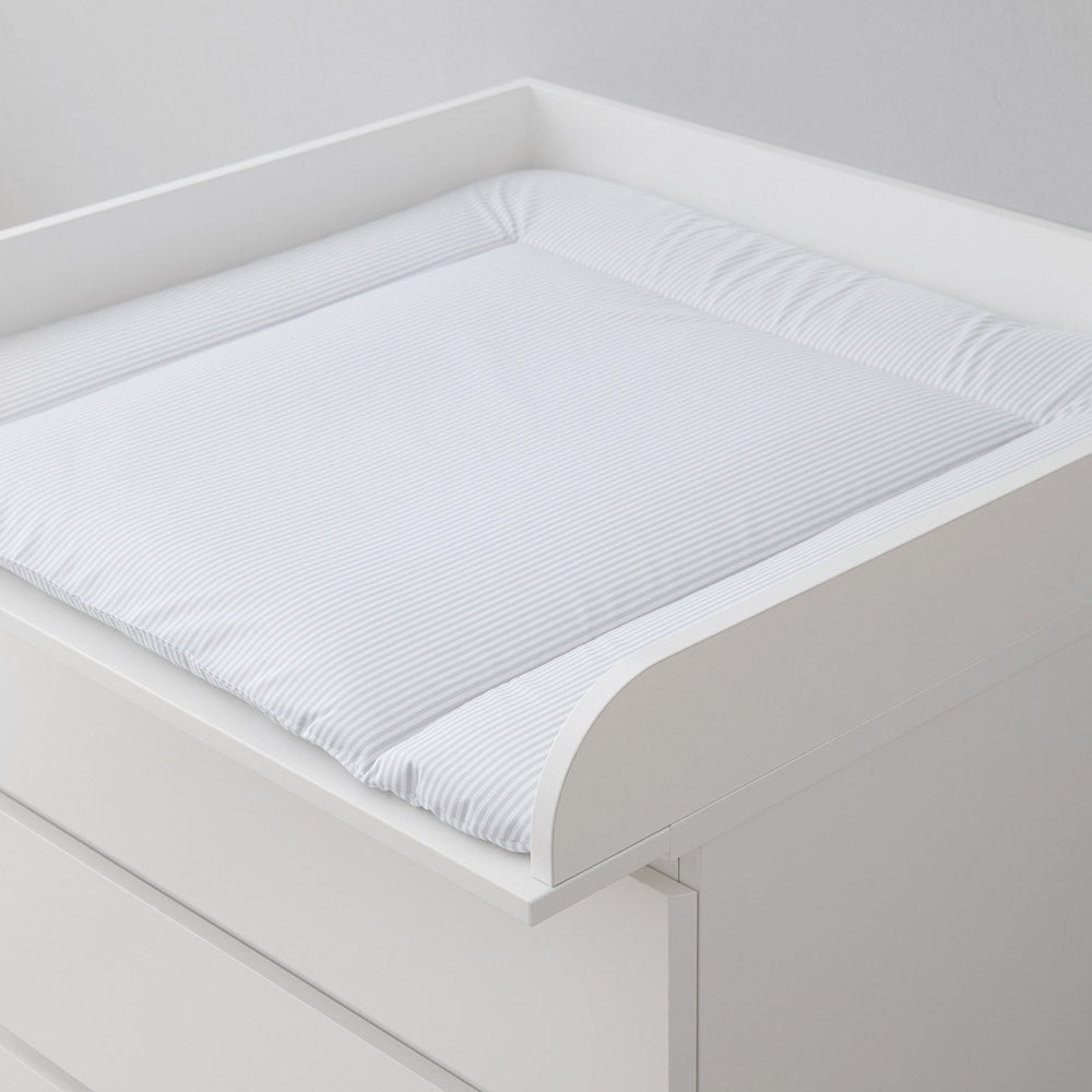 Weiße Wickelauflage mit grauen Streifen auf einer weißen Malm Wickelkommode.
