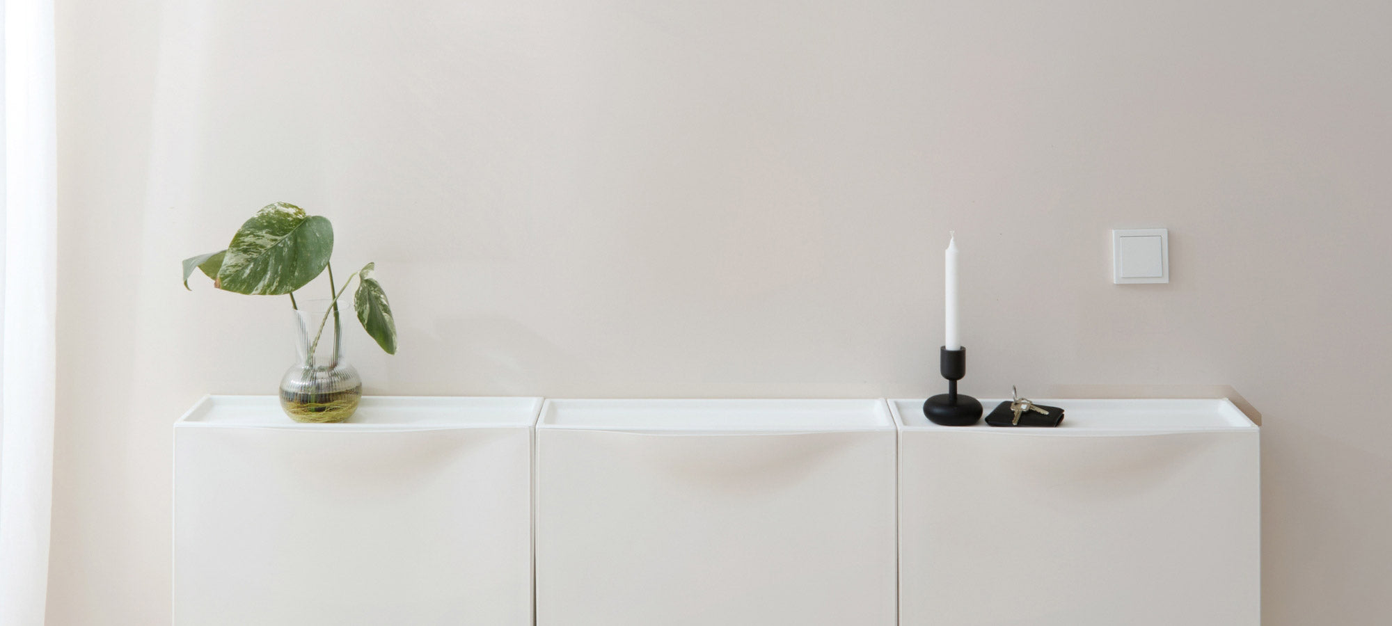 3 weiße nebeneinander hängende IKEA Trones Schuhschränke aus Kunststoff.