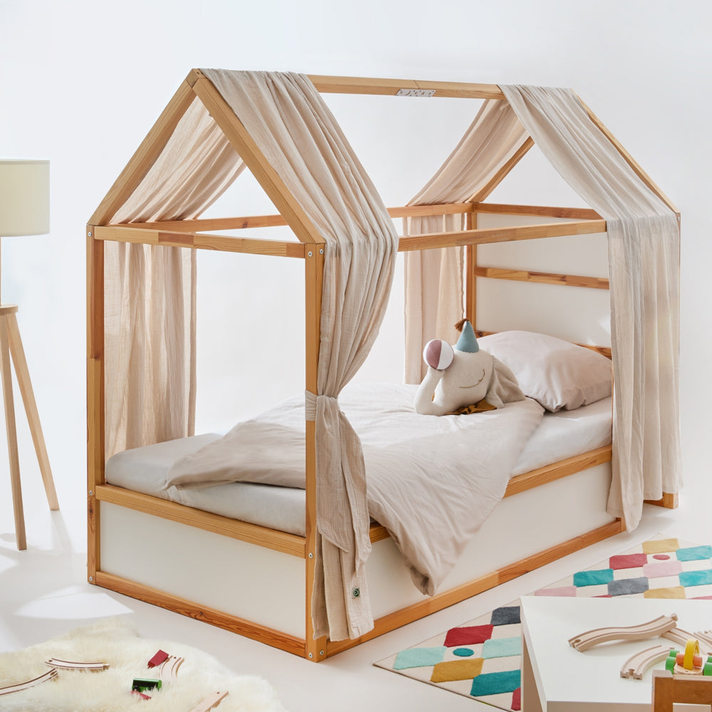 IKEA Kura Bett mit Hausdach und 2 Baldachinen aus beigem Musselinstoff.