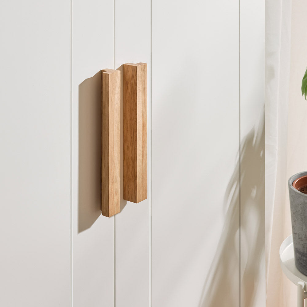 Seitliche Ansicht des IKEA Brimnes Schranks mit zwei Griffen aus Eichenholz.