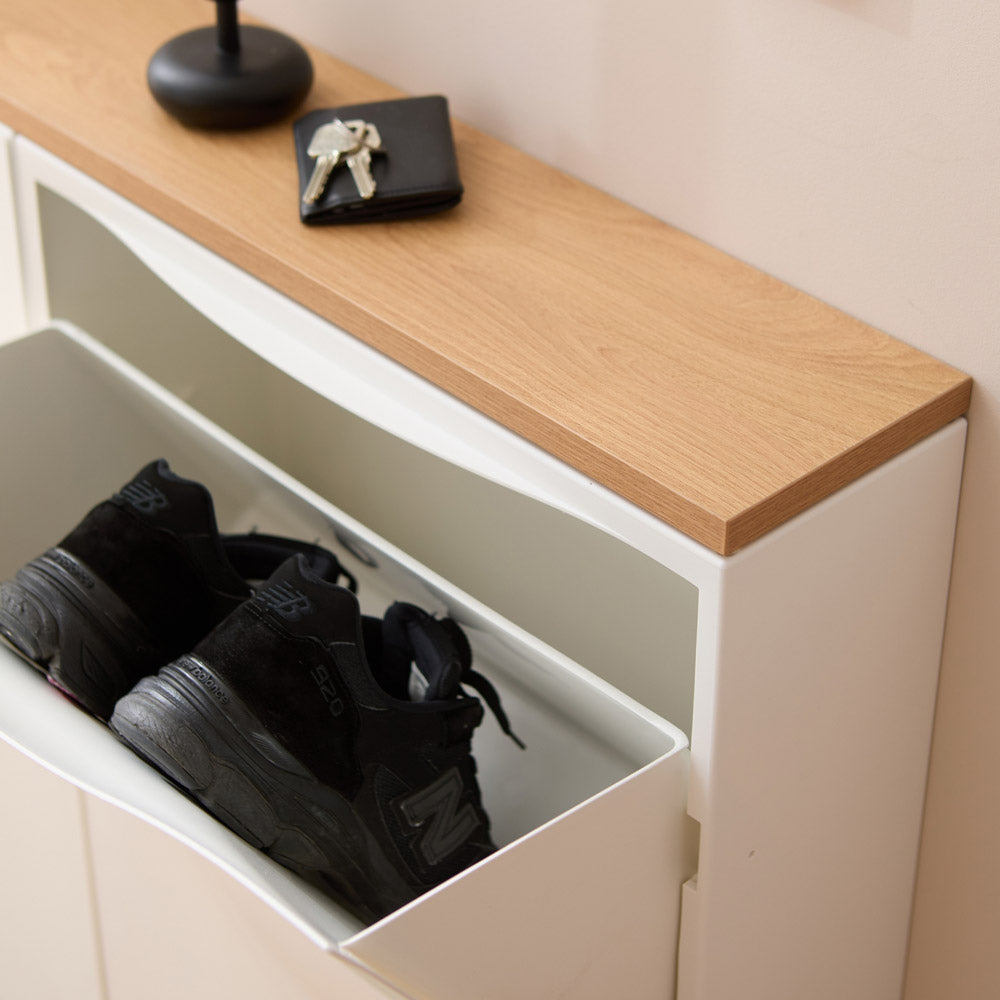 Detailaufnahme von einem geöffneten IKEA Trones Schuhschrank mit Holzplatte.