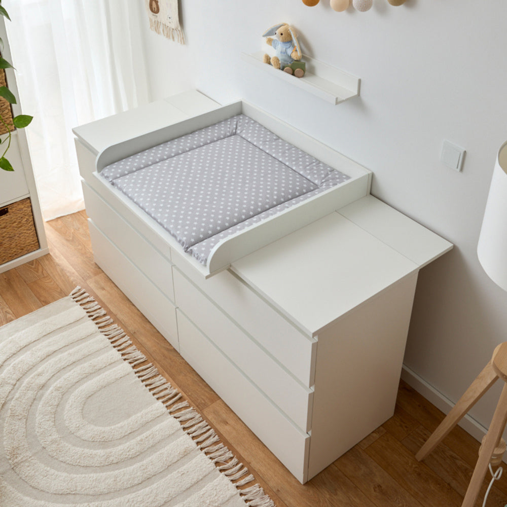 Graue Wickelauflage mit weißen Sternen auf weißer Malm Wickelkommode.