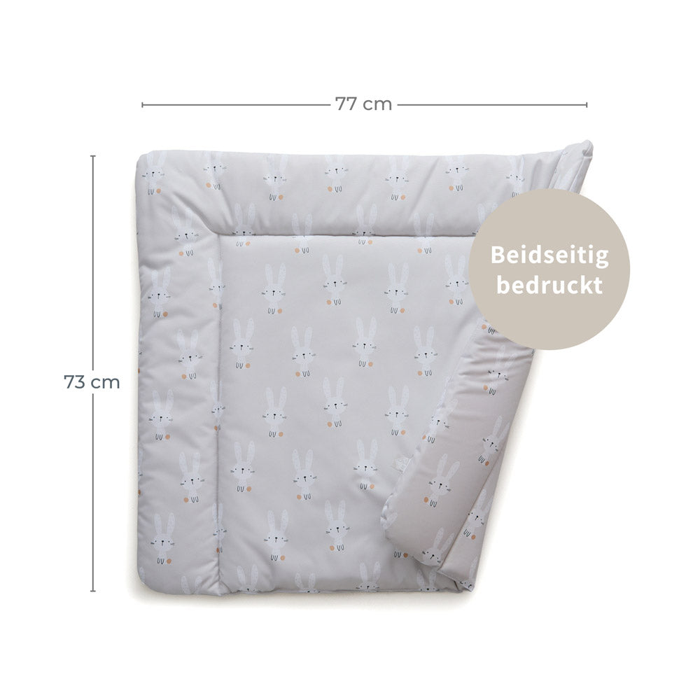 Beidseitig bedruckte Wickelauflage mit Hasen und entsprechenden Maßangaben.