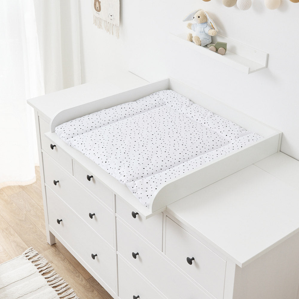 Weiße Wickelauflage mit schwarzen Punkten auf einer Hemnes Wickelkommode.