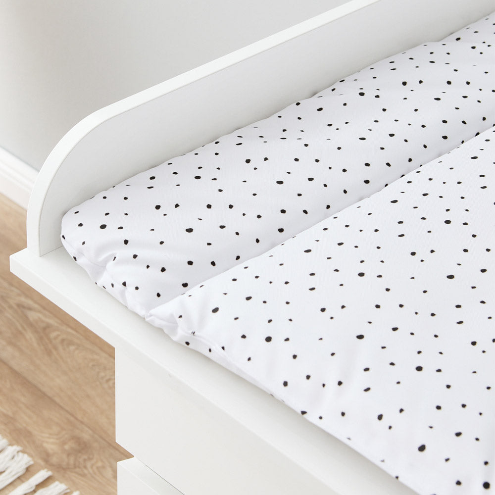 Detailaufnahme einer weißen Wickelauflage mit schwarzen Punkten.